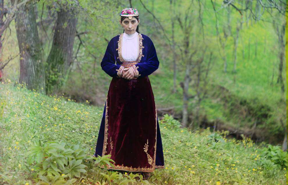 Armenian woman in national costume poses of Prokudin-Gorskii on a hillside near Artvin, circa 1910.
