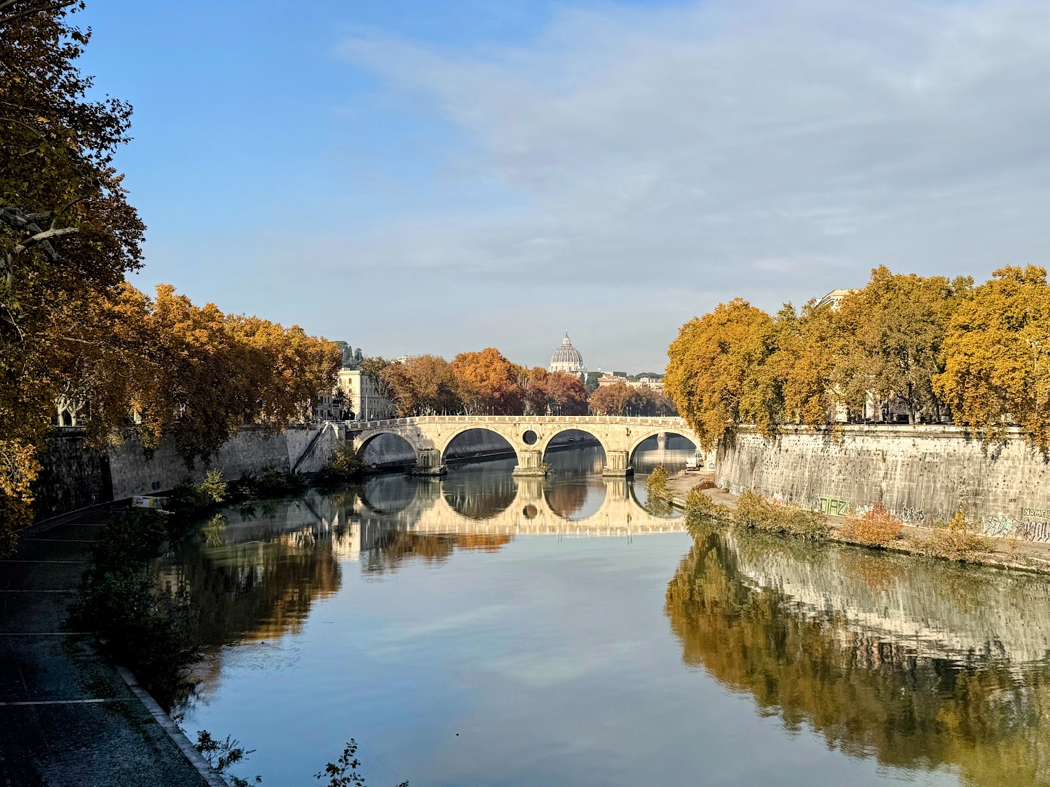 The Tiber River, Rome, with Ponte Sisto in the foreground and the dome of St. Peter's Basilica in the background.